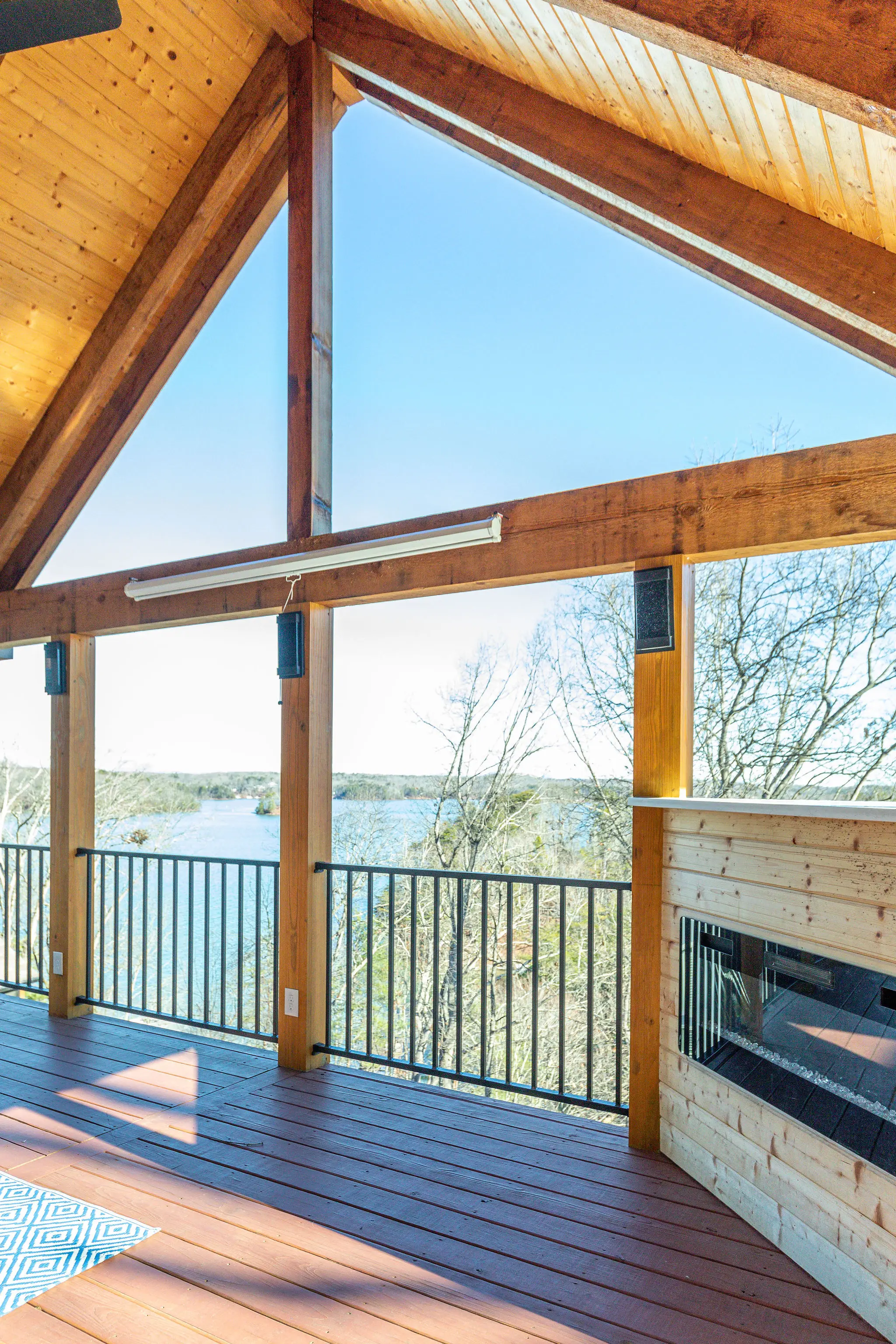 Covered porch with outdoor fireplace and lake view