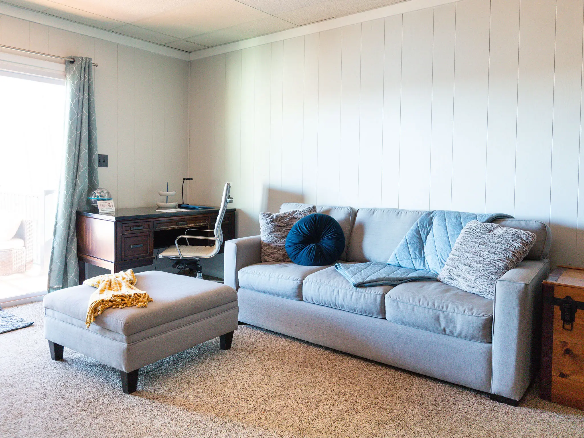 Lower-level lounge with sofa, ottoman and desk