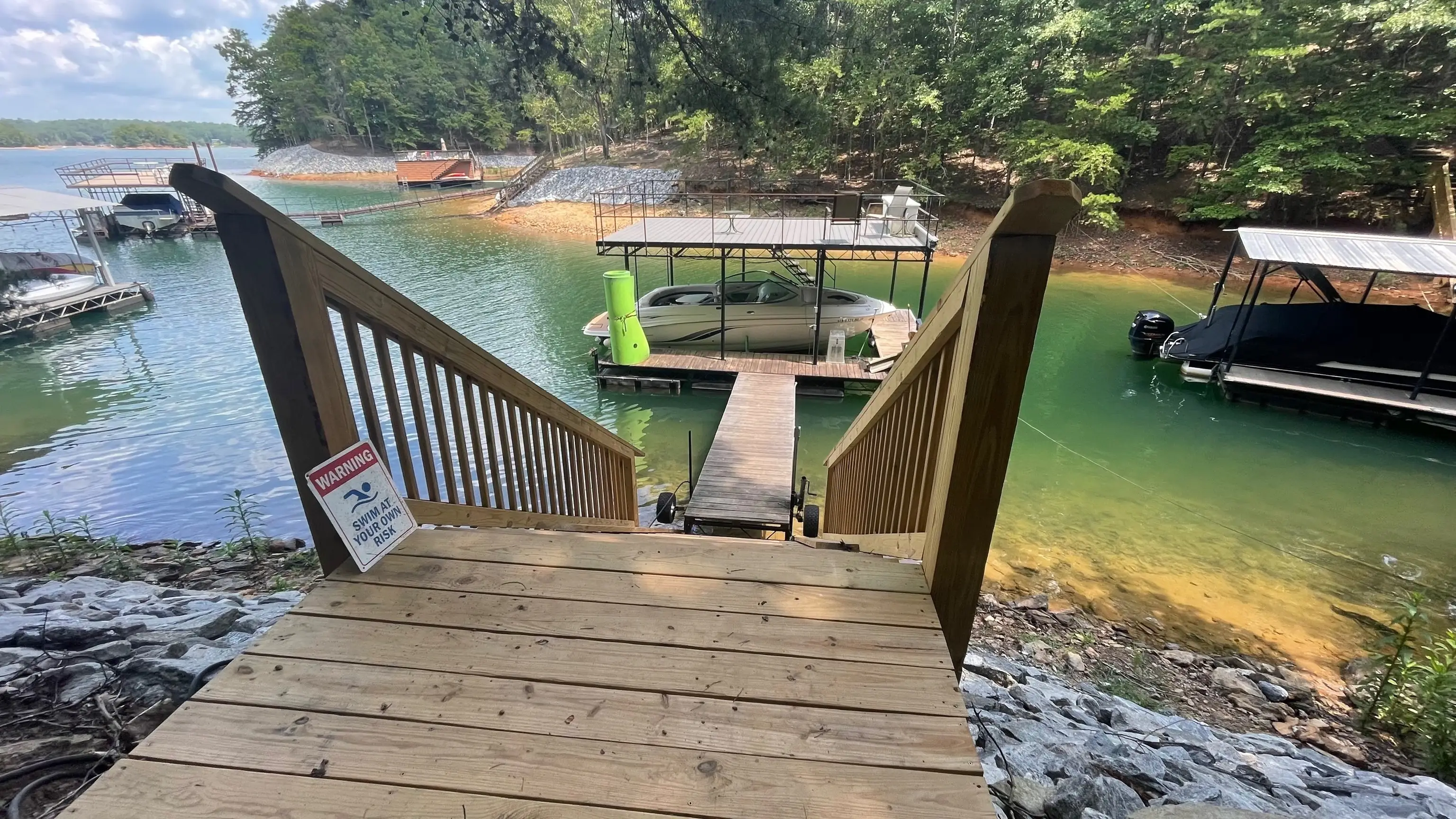 Dock and covered boat lift seen from the top of the stairs