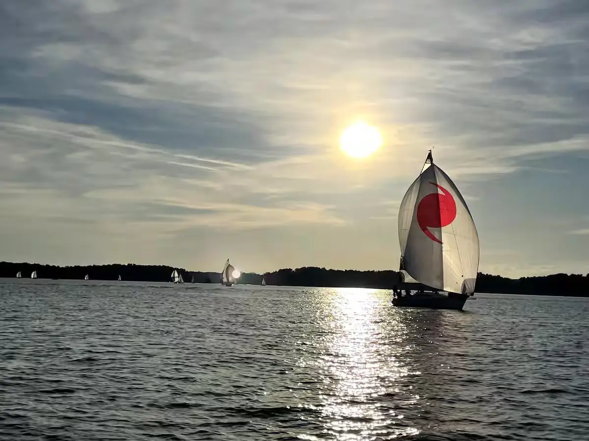 Sailboat with a red spinnaker on Lake Lanier at sunset