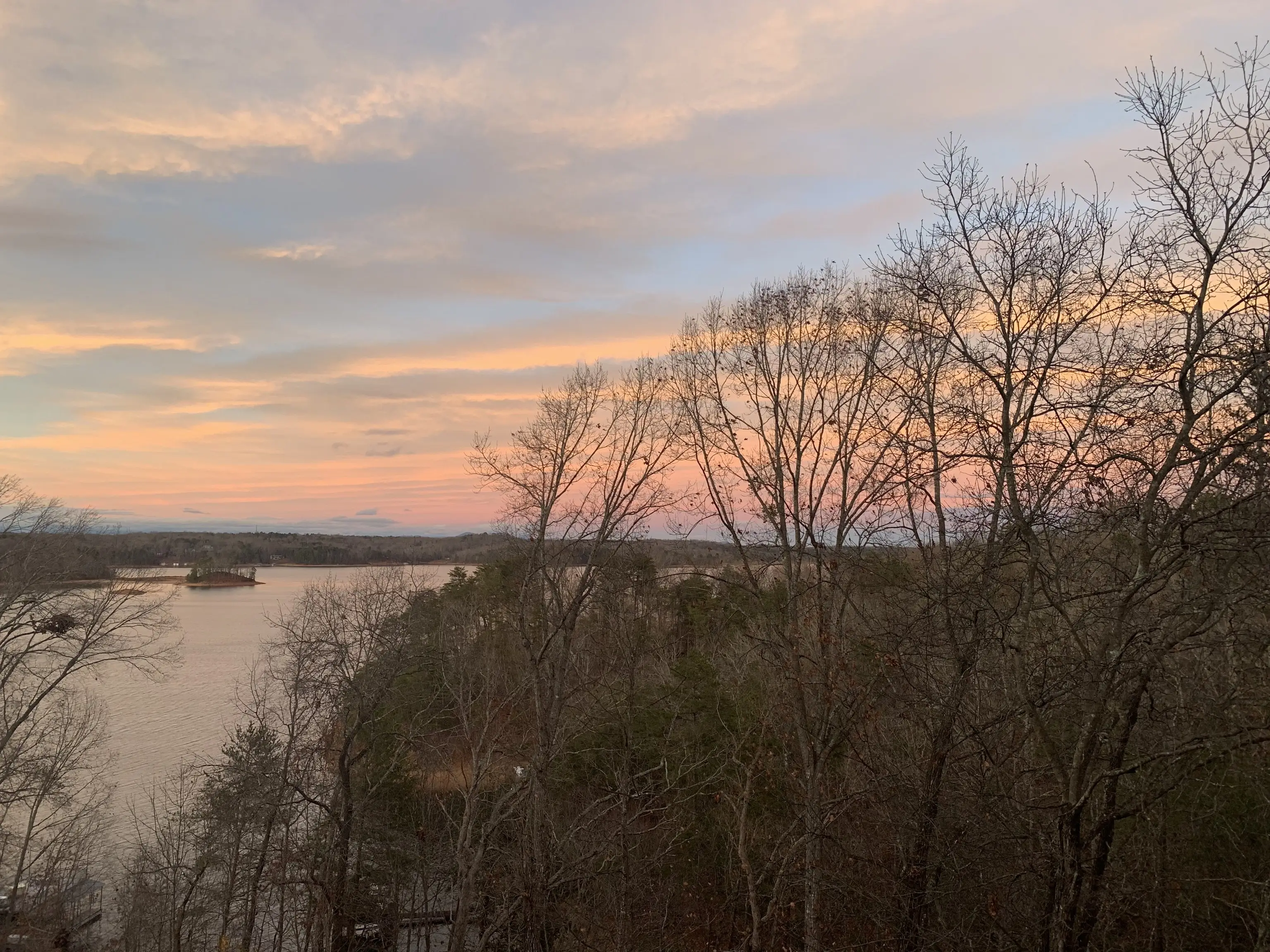 Winter sunset over Lake Lanier through bare trees